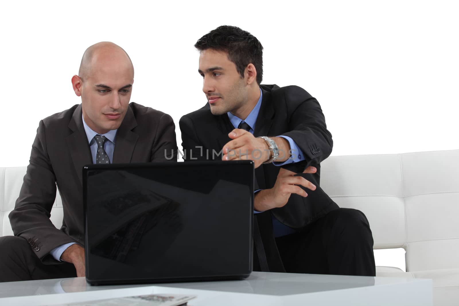 Businessmen looking at a laptop by phovoir