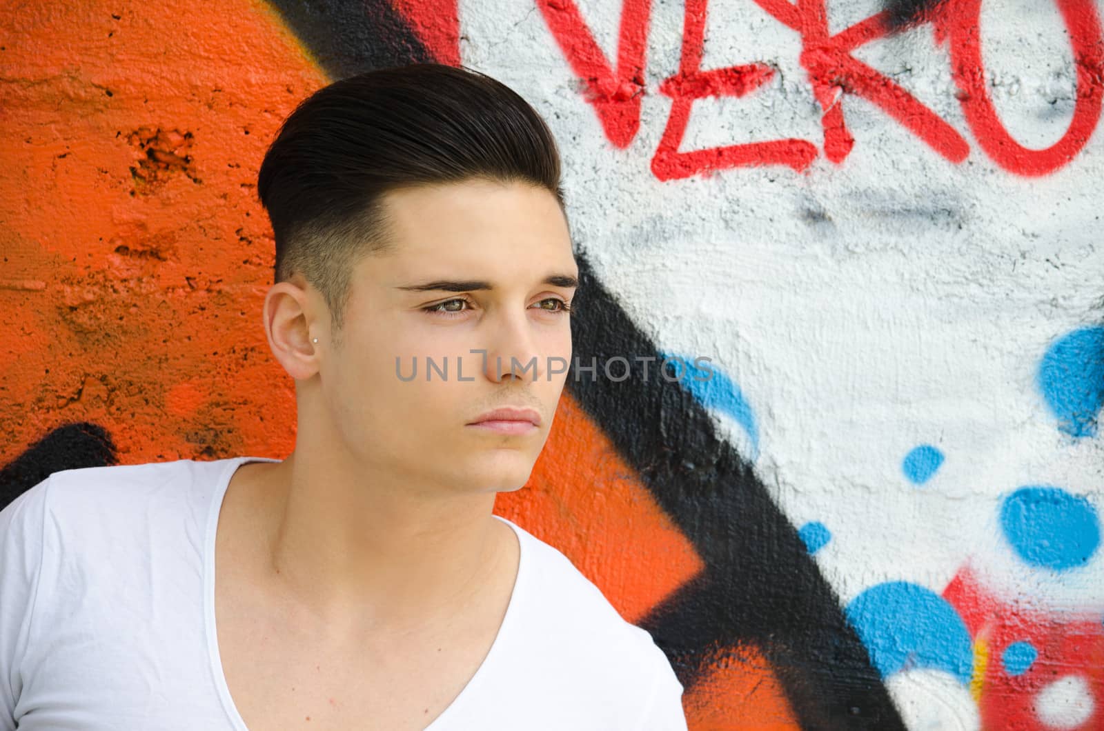 Good looking young man against graffiti wall by artofphoto