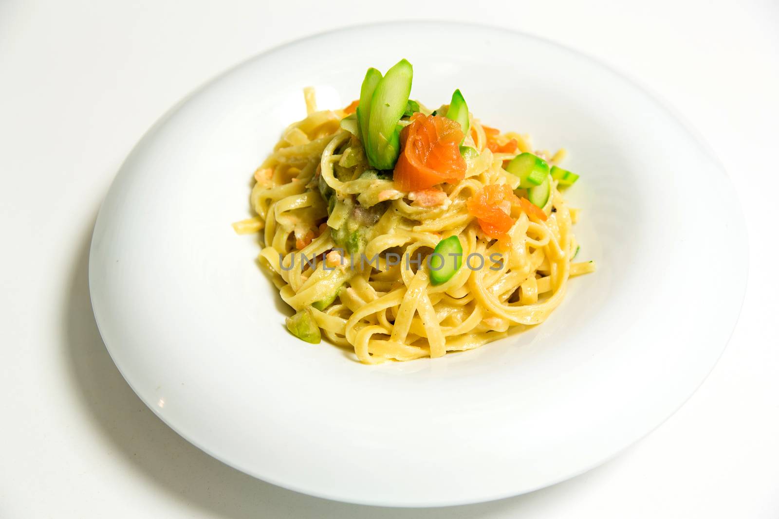 Pasta fettuccine with salmon served on a white dish
