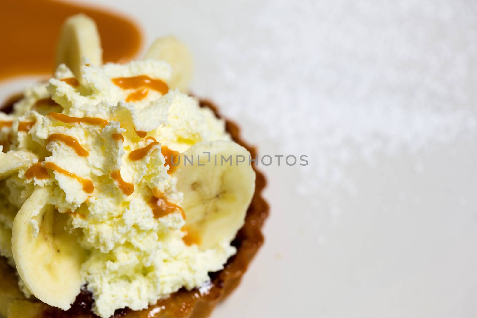 A fresh banana cream pie ready to be served to guests. Toppings of honey