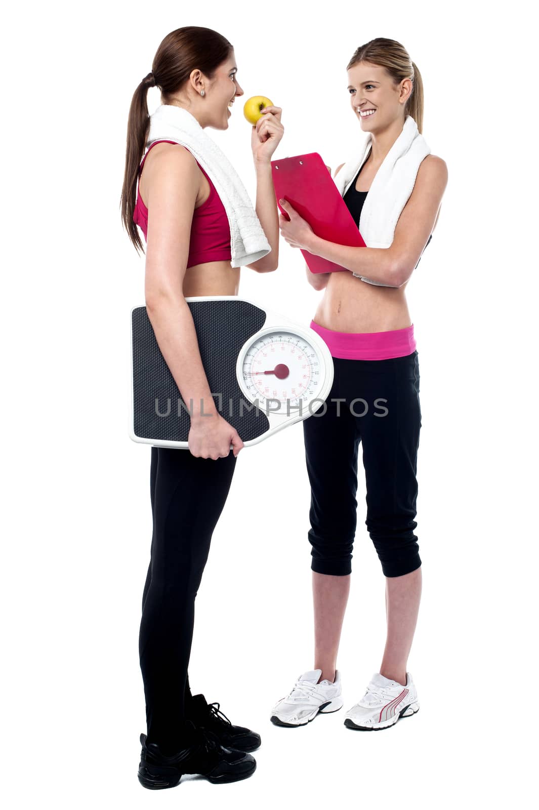 Female trainer writing diet chart for gym member by stockyimages
