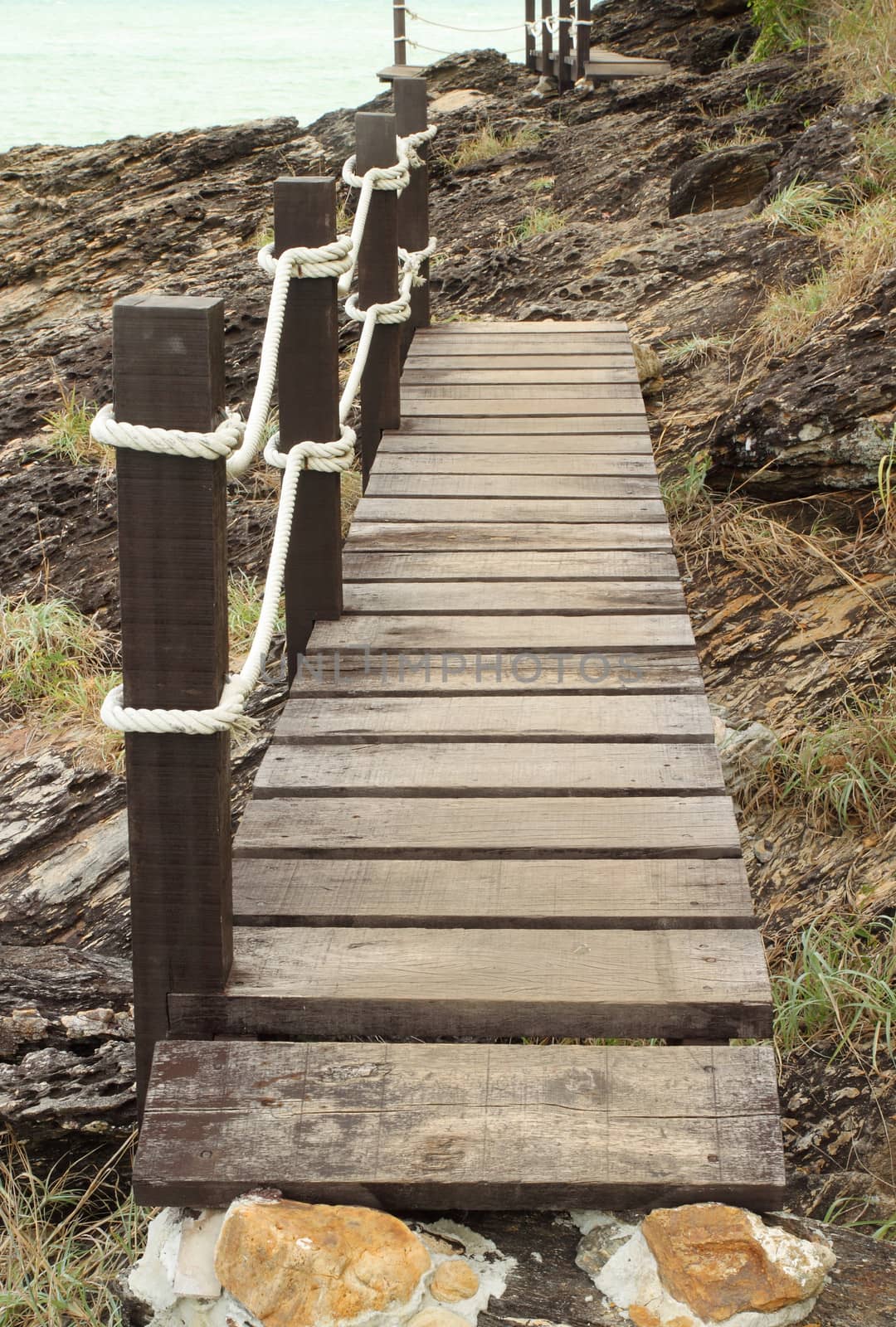 wooden walk way on the sea stone