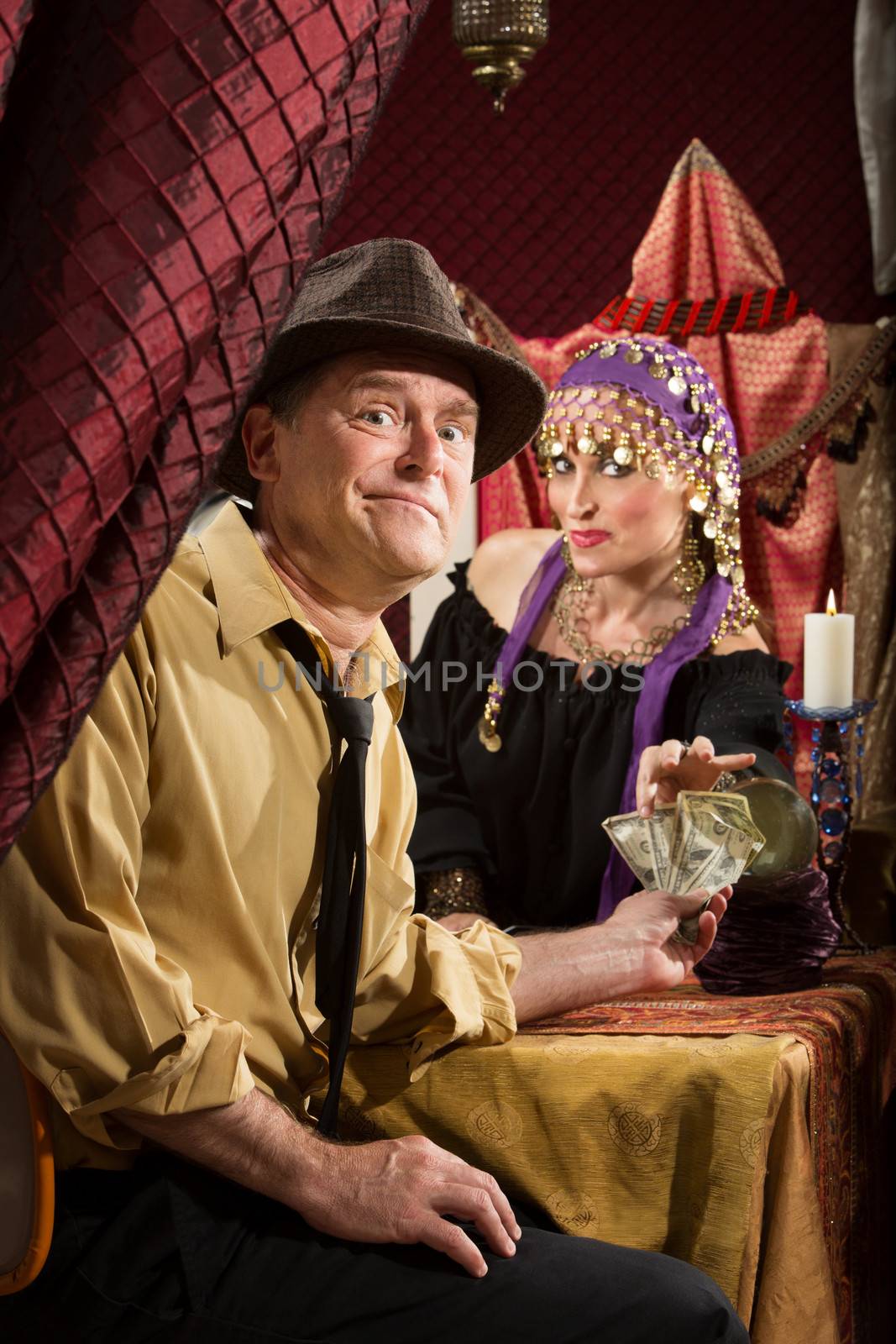 Disappointed man paying fortune teller cash money