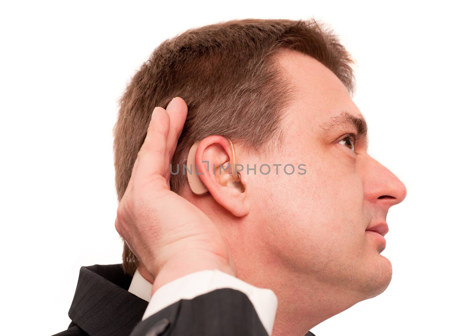 Deaf man wearing hearing aid listening for a quiet sound. Isolated on white.
