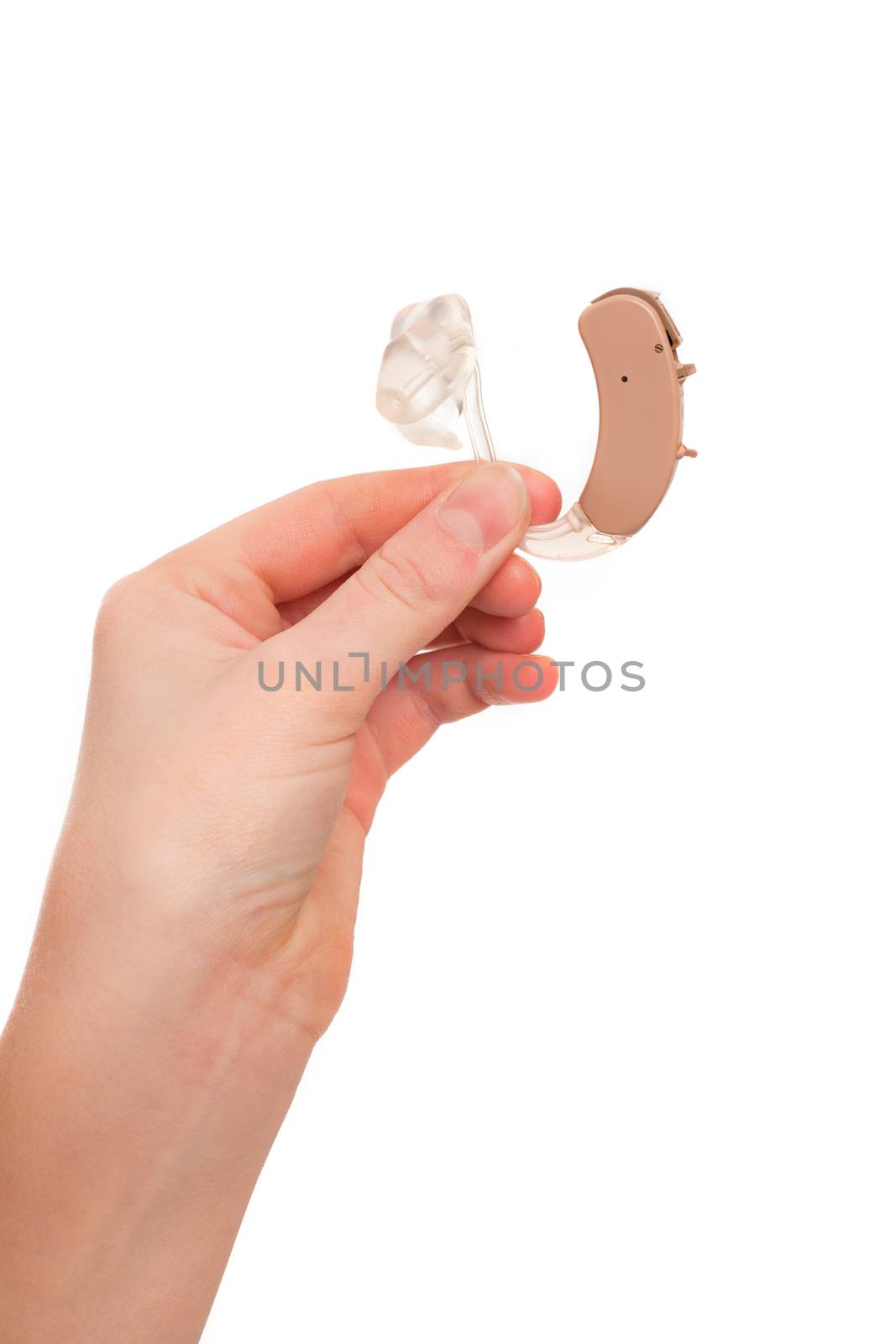 Young female's hand holding a hearing aid between fingers. Isolated on white