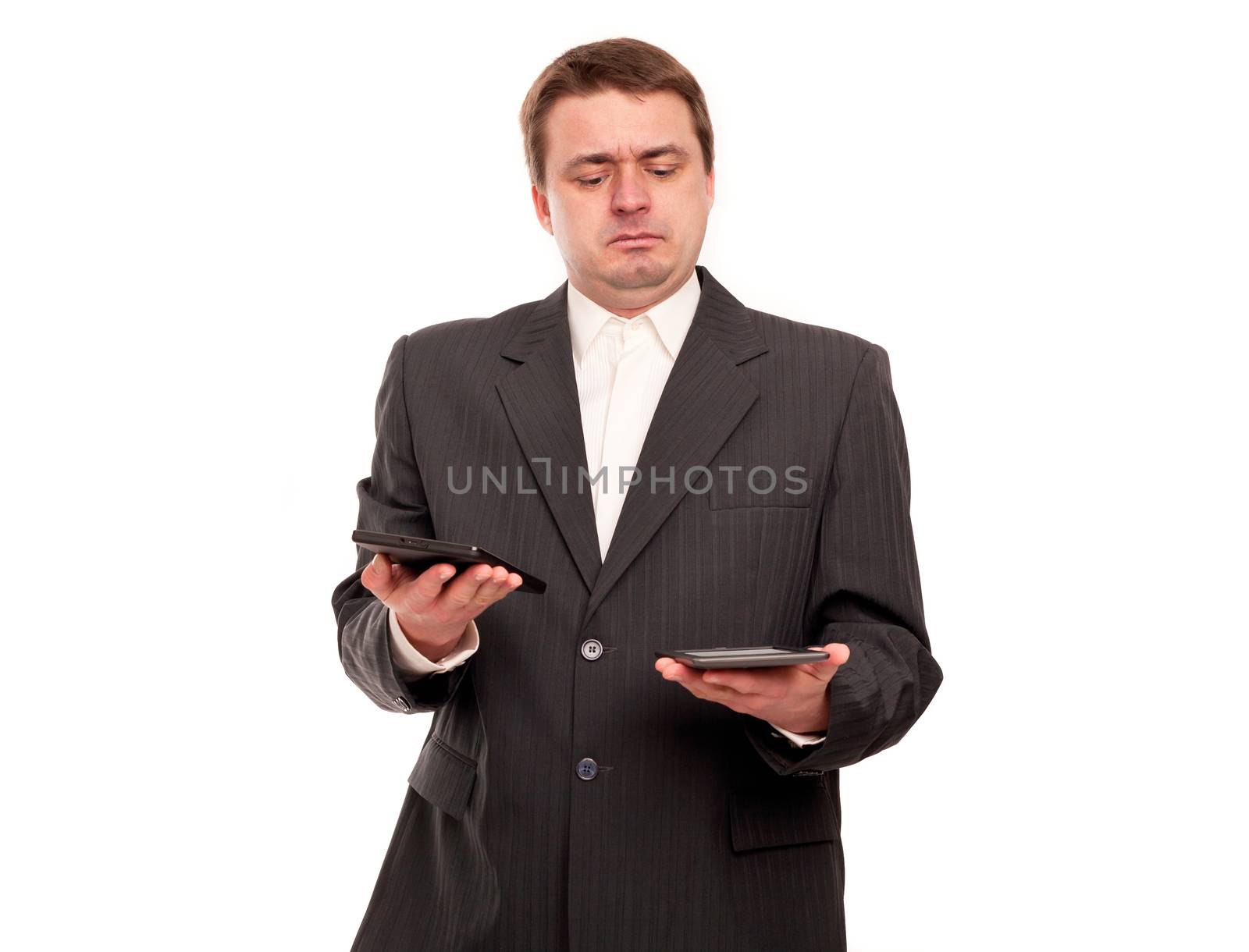 Businessman trying to choose between two tablets.