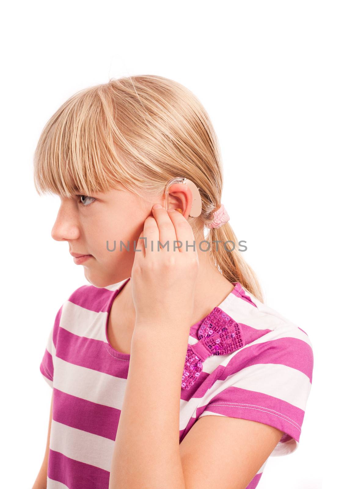 Setting a Hearing aid - Young female setting her hearing aid isolated on white