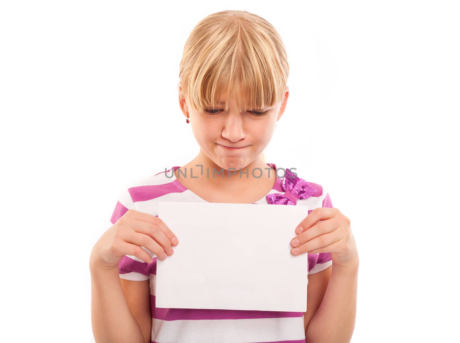 Sad girl holding an empty paper sheet suitable for text. Isolated on white background