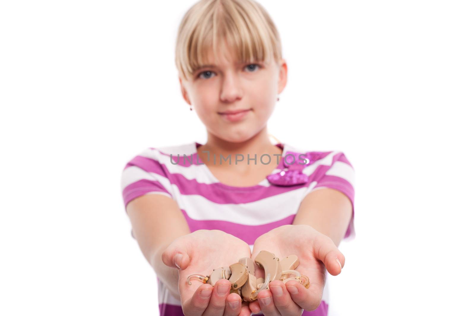 Hearing aids - Teen girl holding lots of hearing aids in her hands. Isolated on white