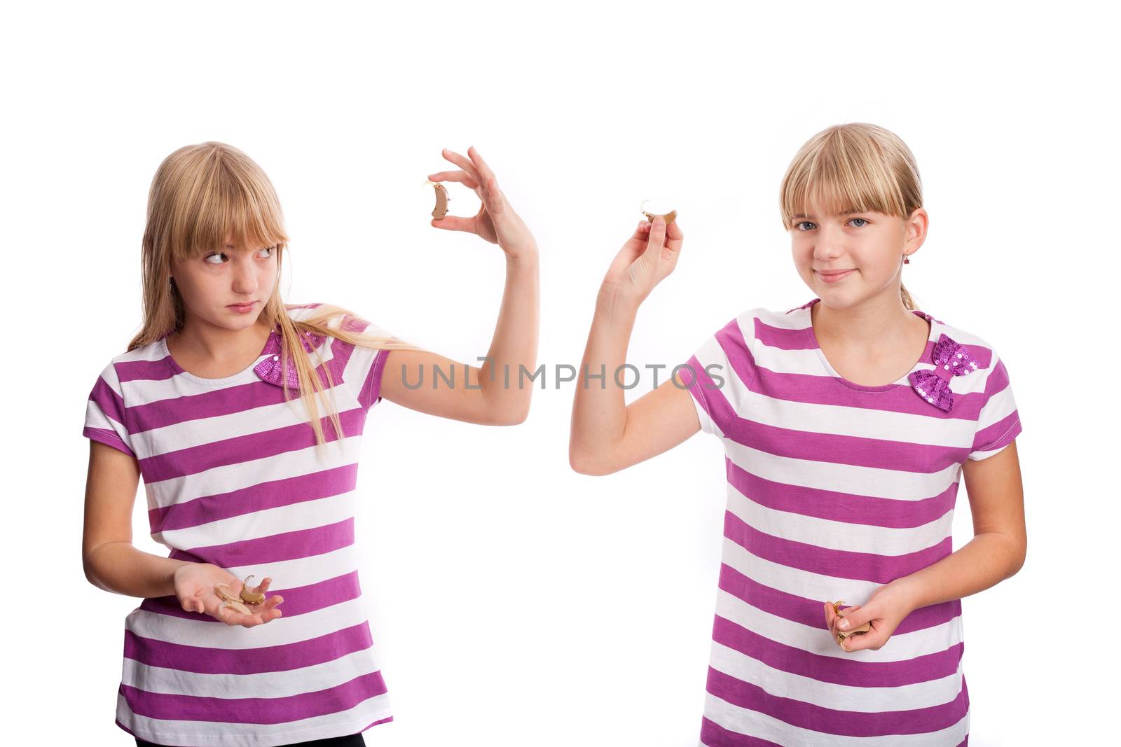 Selecting a hearing aid - Two girls trying to select the suitable hearing aid.  Isolated on white