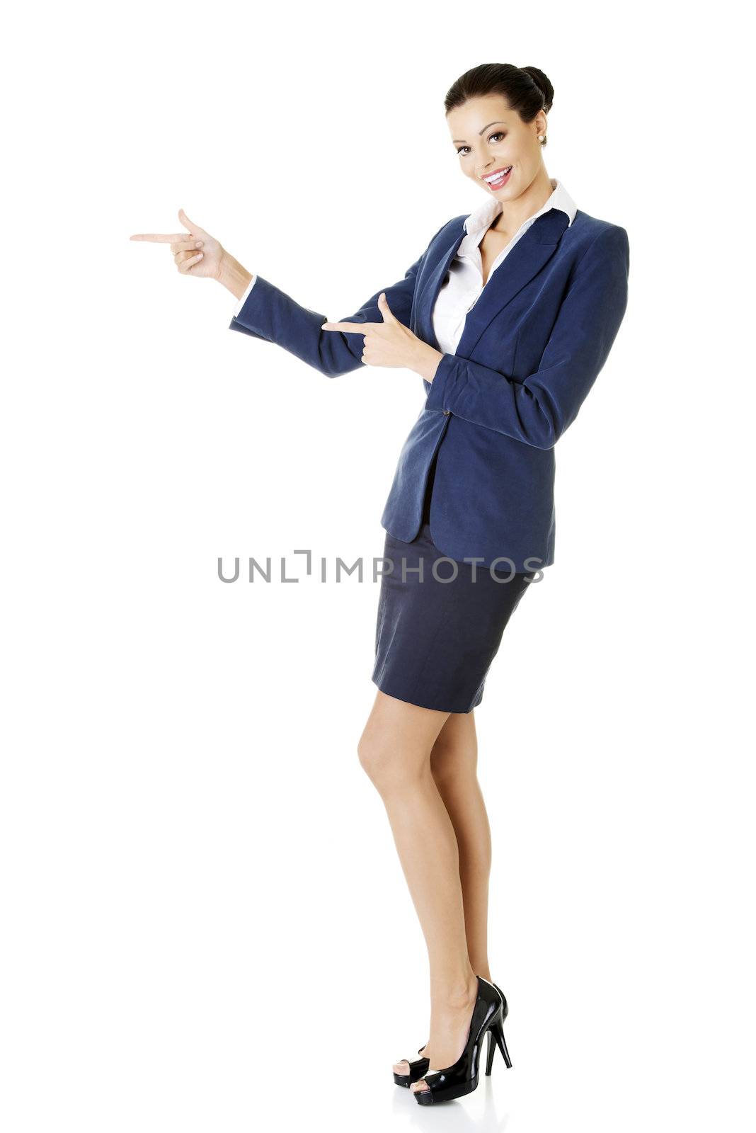 Happy young business woman pointing on copy space, isolated on white