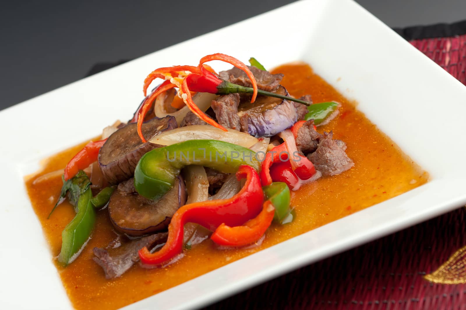 A beautifully presented dish of Thai food with mixed vegetables beef and brown rice.