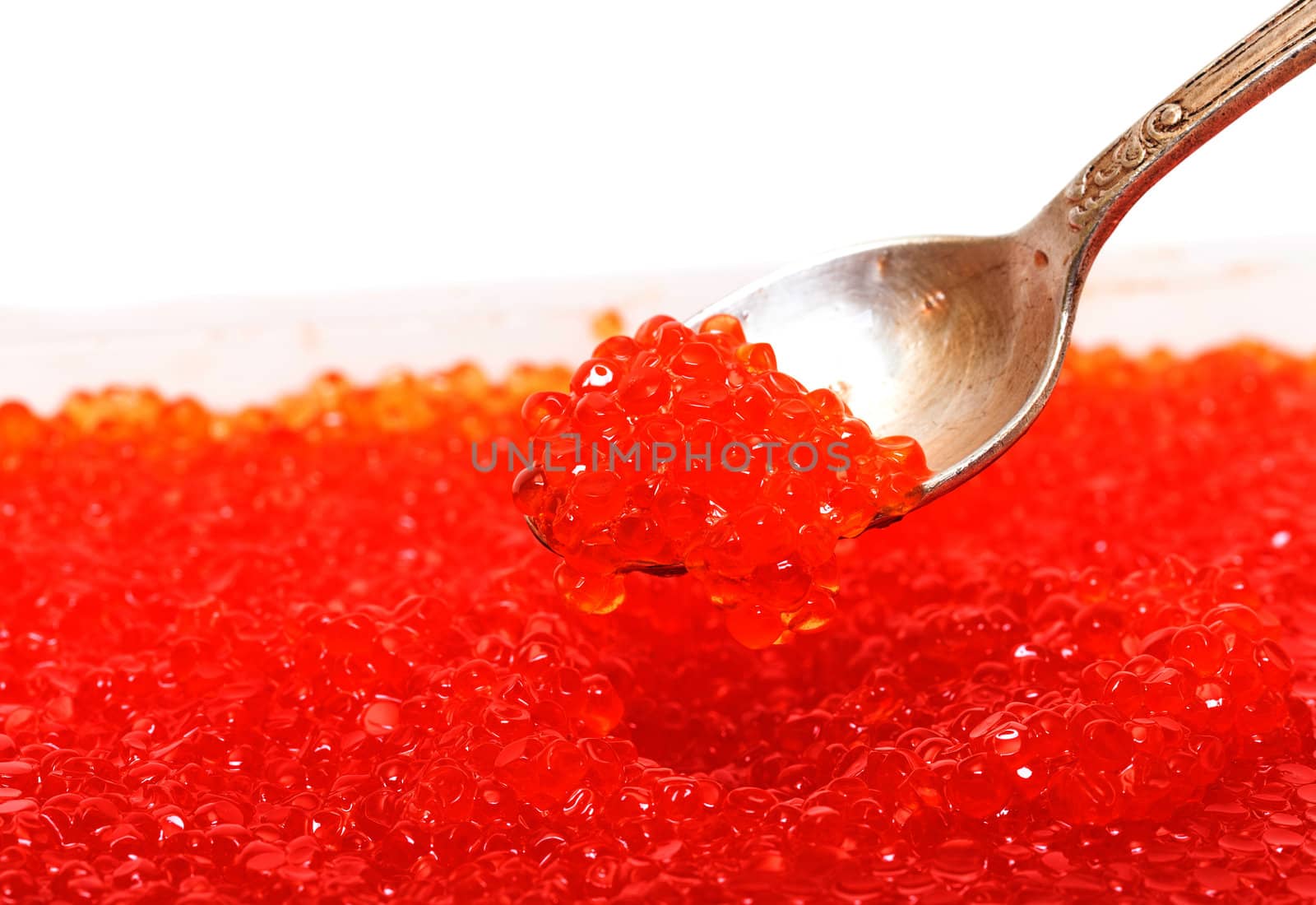 Red salted caviar with spoon on a white background