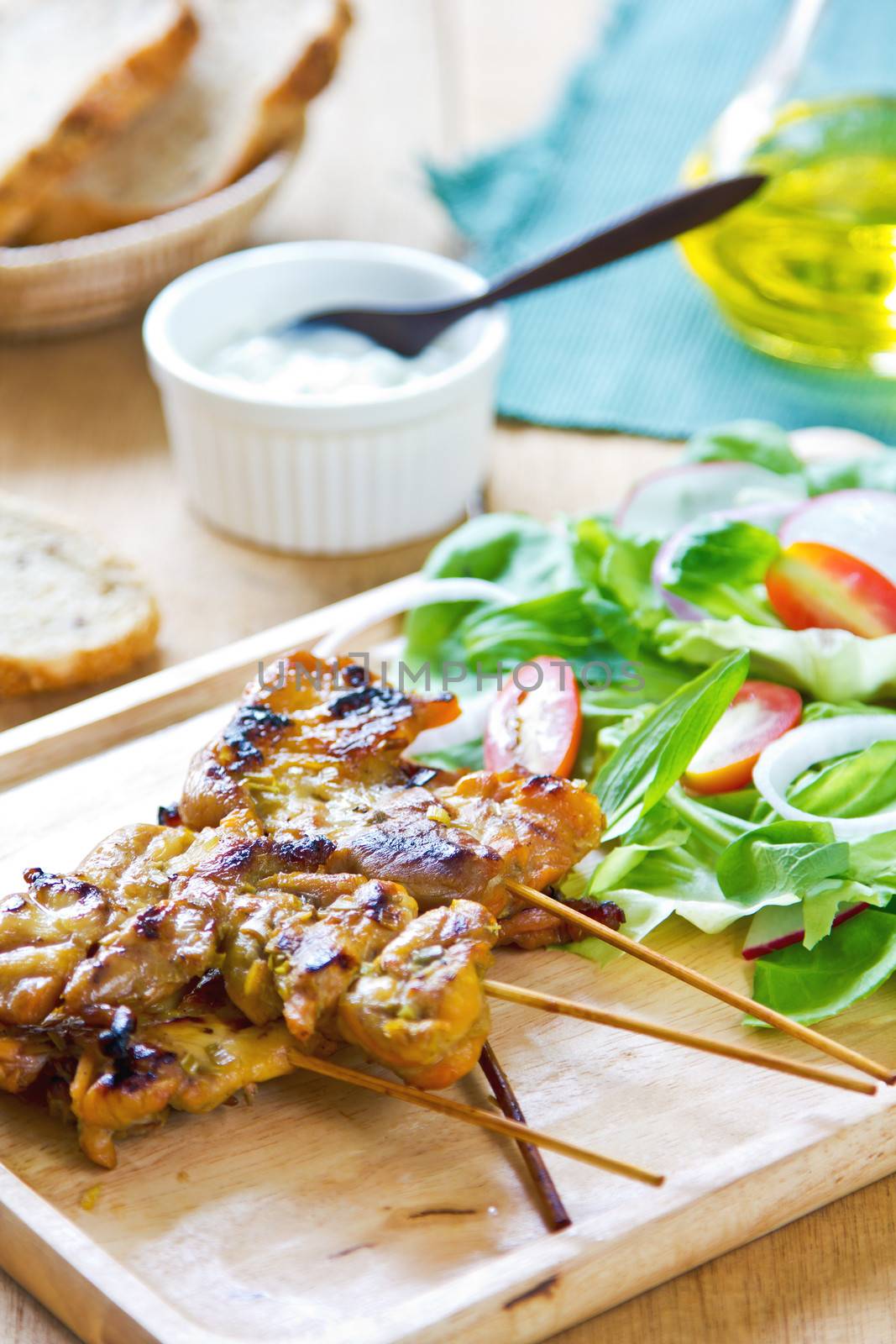 Grilled chicken skewer with salad by vanillaechoes