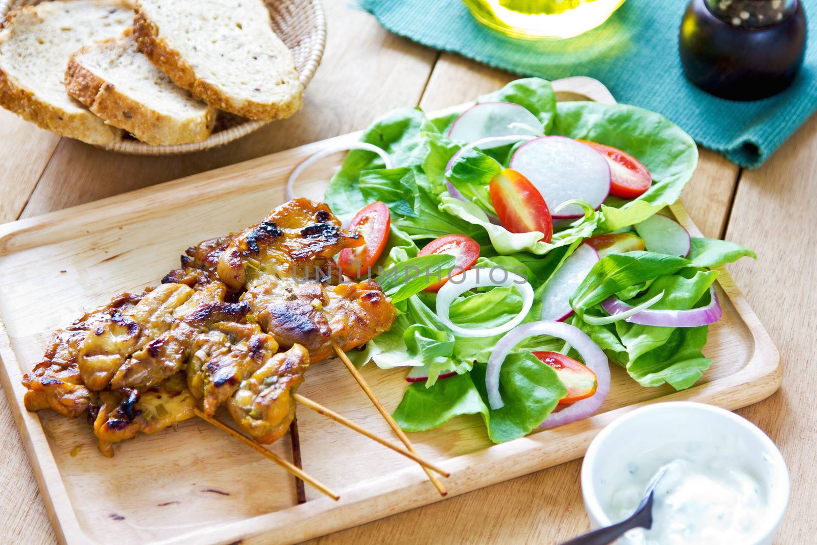 Grilled chicken skewer with salad and yogurt sauce