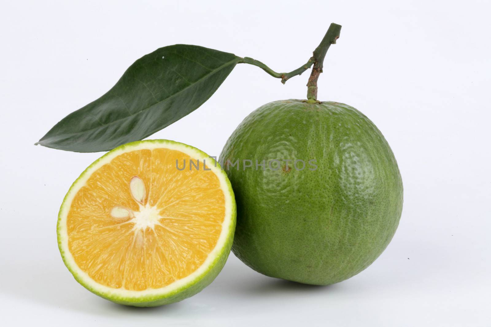 whole Sweet orange and portion with leaf in white background