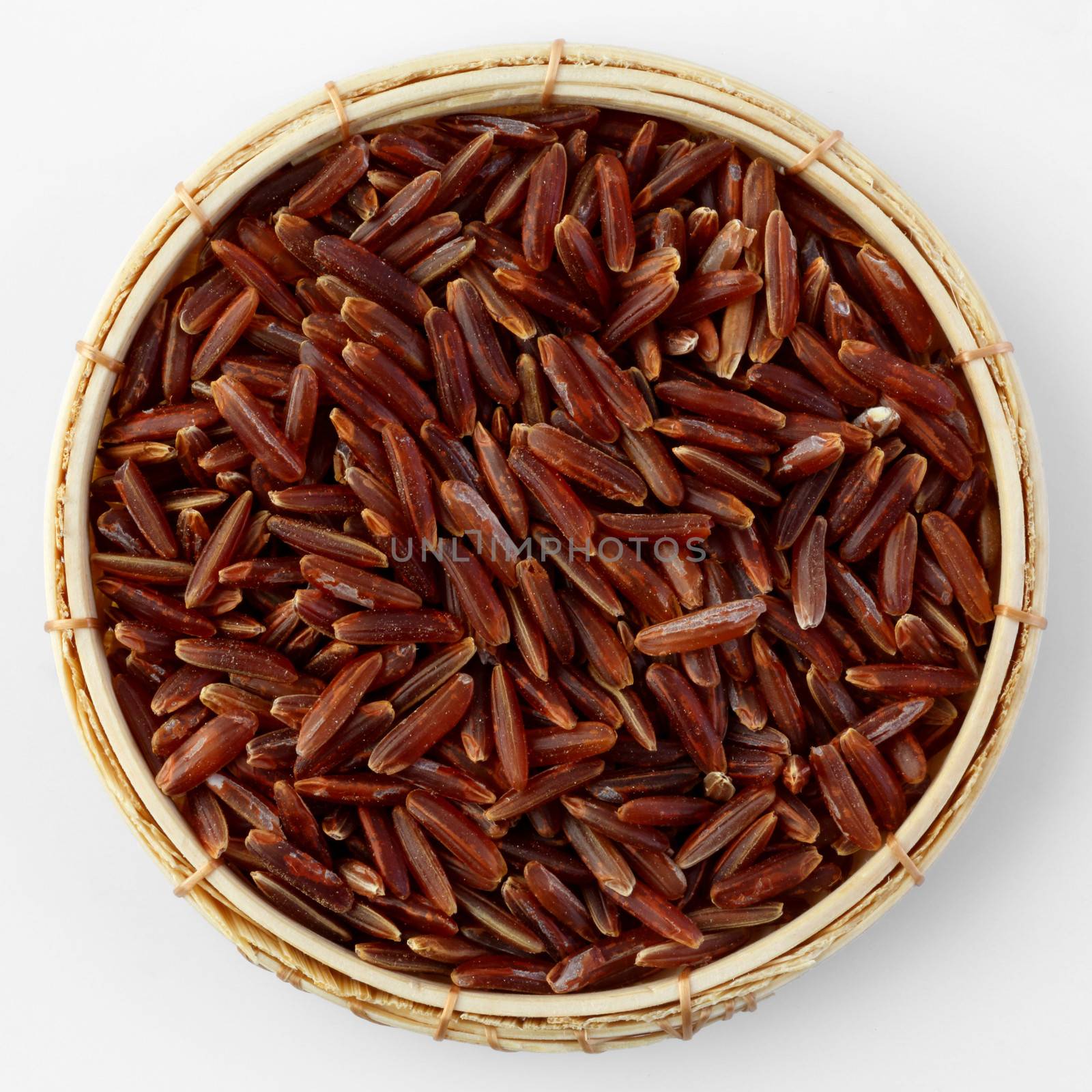 Thai brown jasmine rice in bamboo basket isolated on white