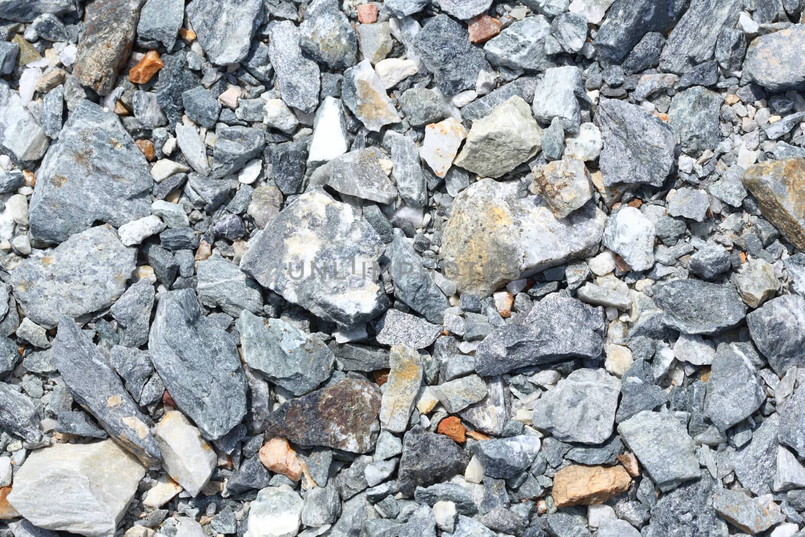 Multicolored crushed stone in bright sunlight day