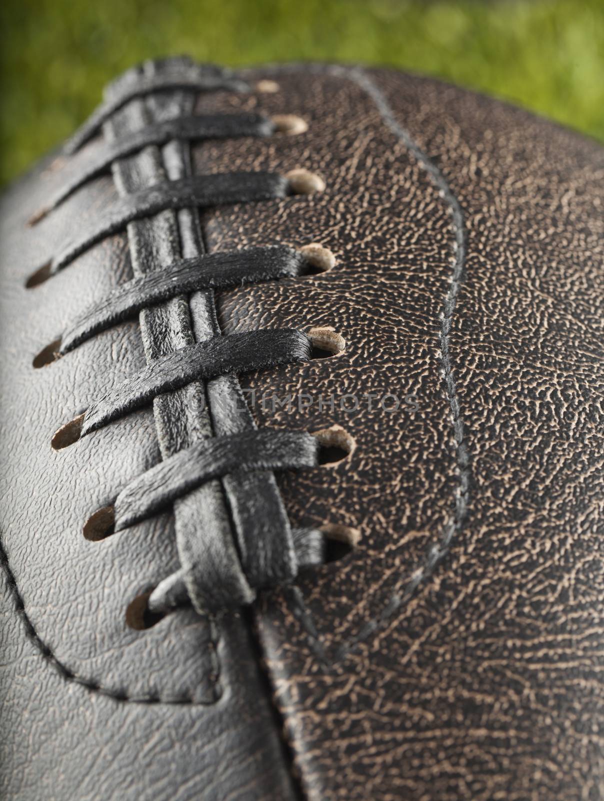 Strict close up of a football over green grass