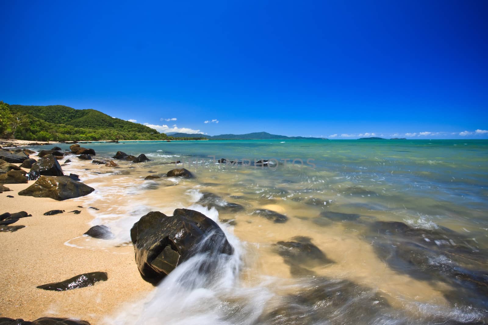 Landscape waves on rocks over the bright blue sky