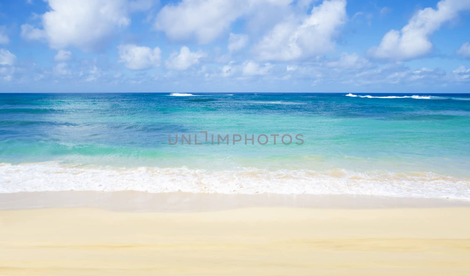 Gentle waves on the sandy Poipu beach in Hawaii, Kauai