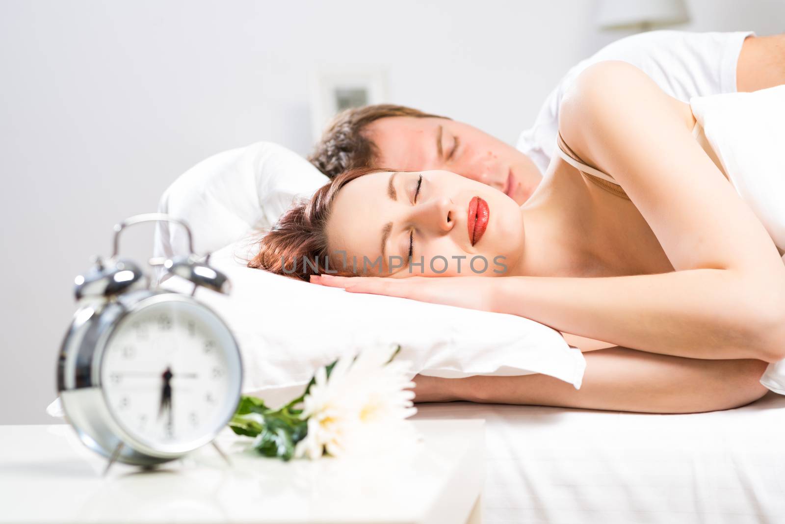 young beautiful woman sleeping on the bed with her husband