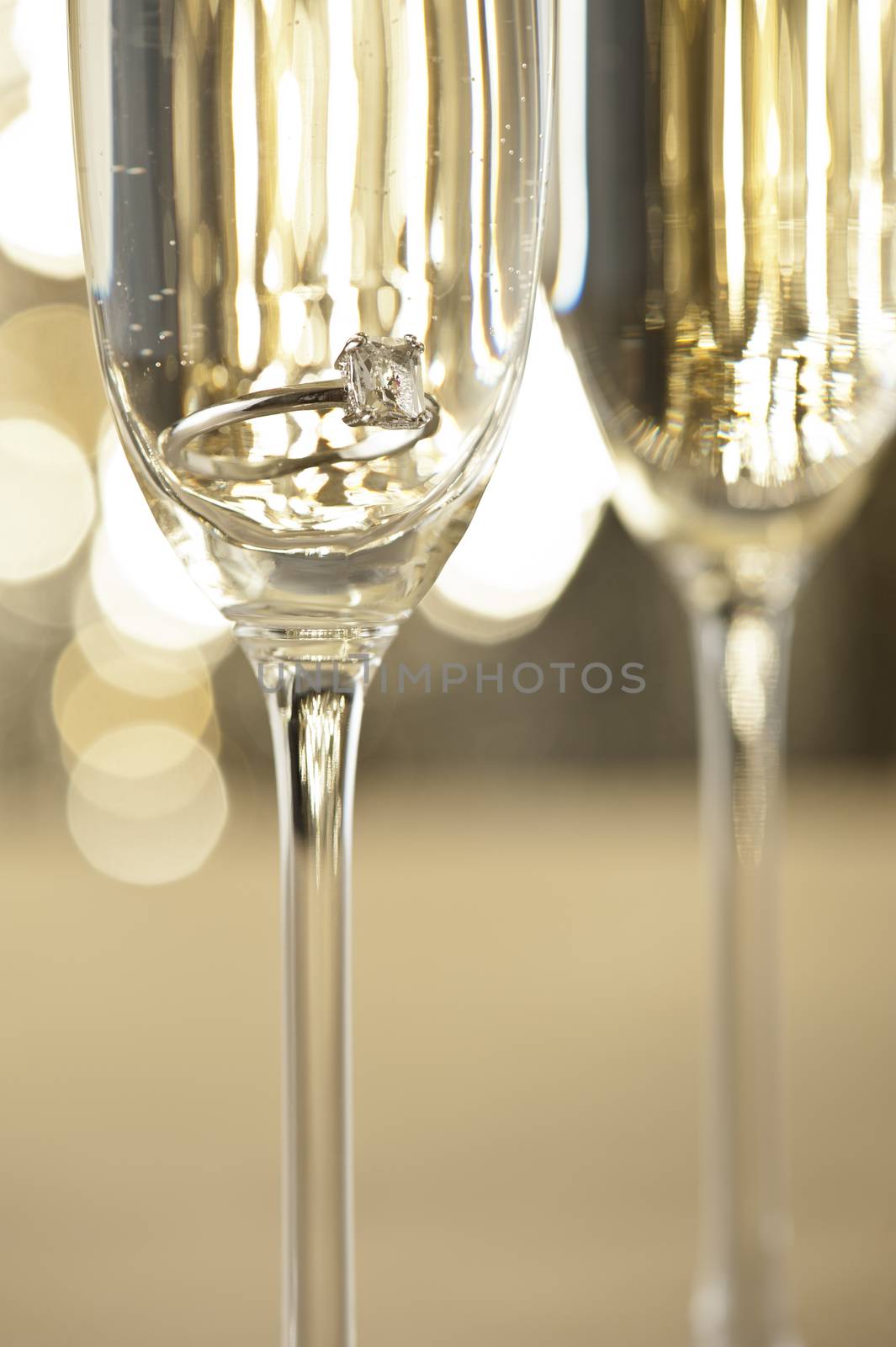 Champagne glasses with engagement Jewelry in front of autumn background