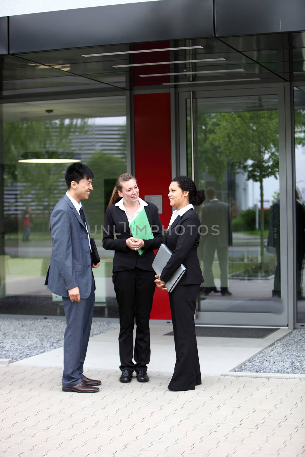 Three businesspeople talking outside the office building
