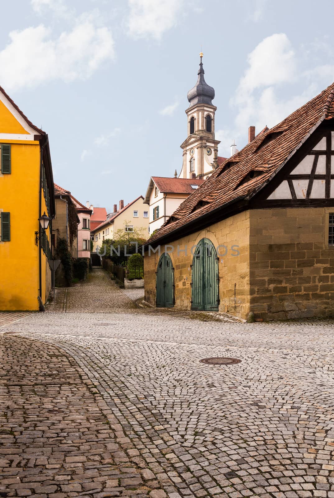 Evangelical Lutheran church of St Johannis or Johannes in small Bavarian village of Castell in Germany. Church rises above the old homes and cobbled streets of the town
