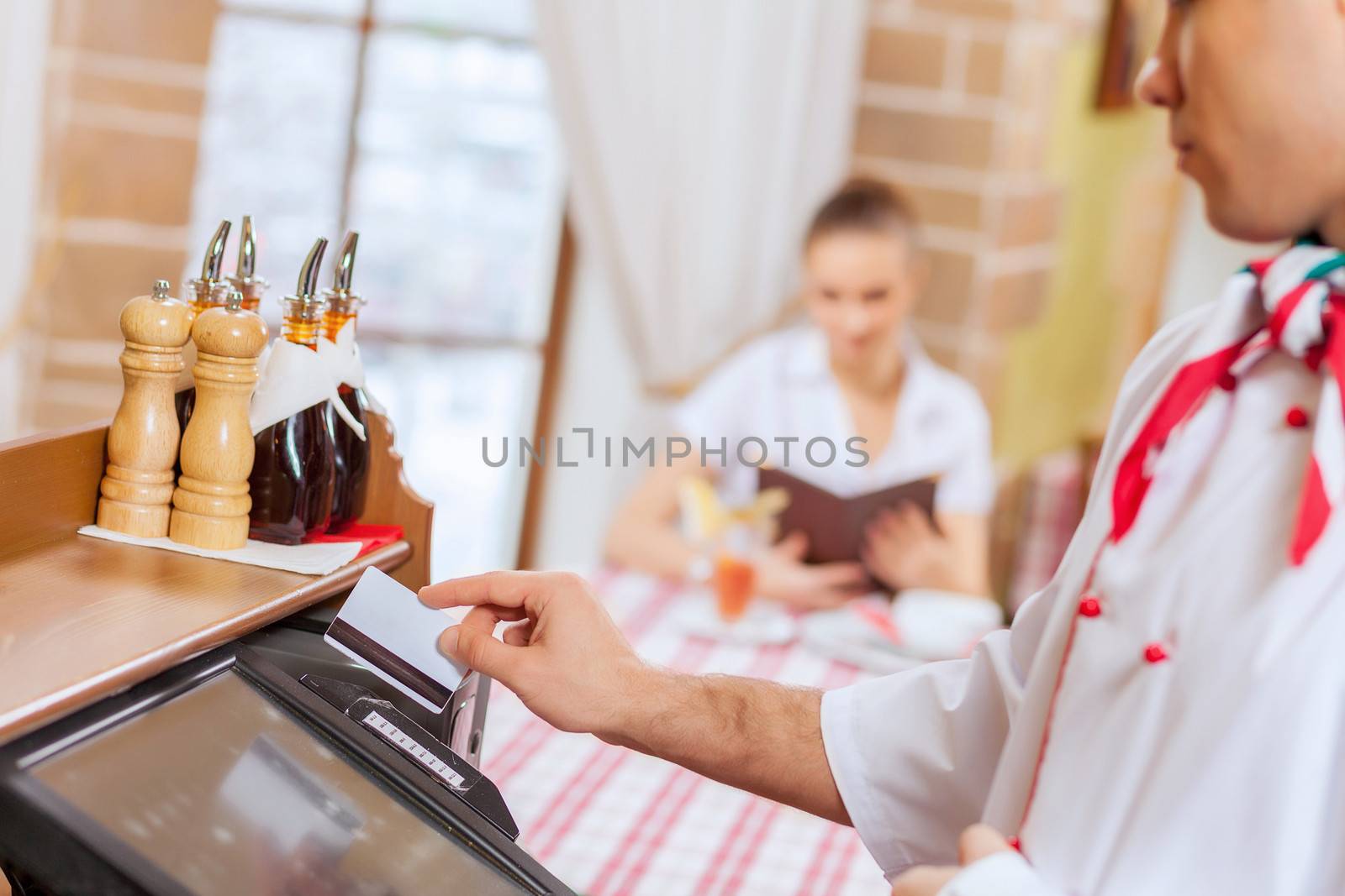 Image of handsome chef inserting card in terminal