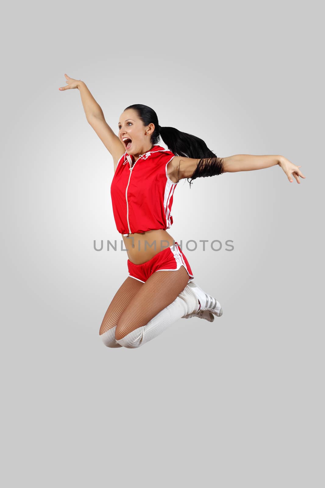 Young female dancer jumping against white background