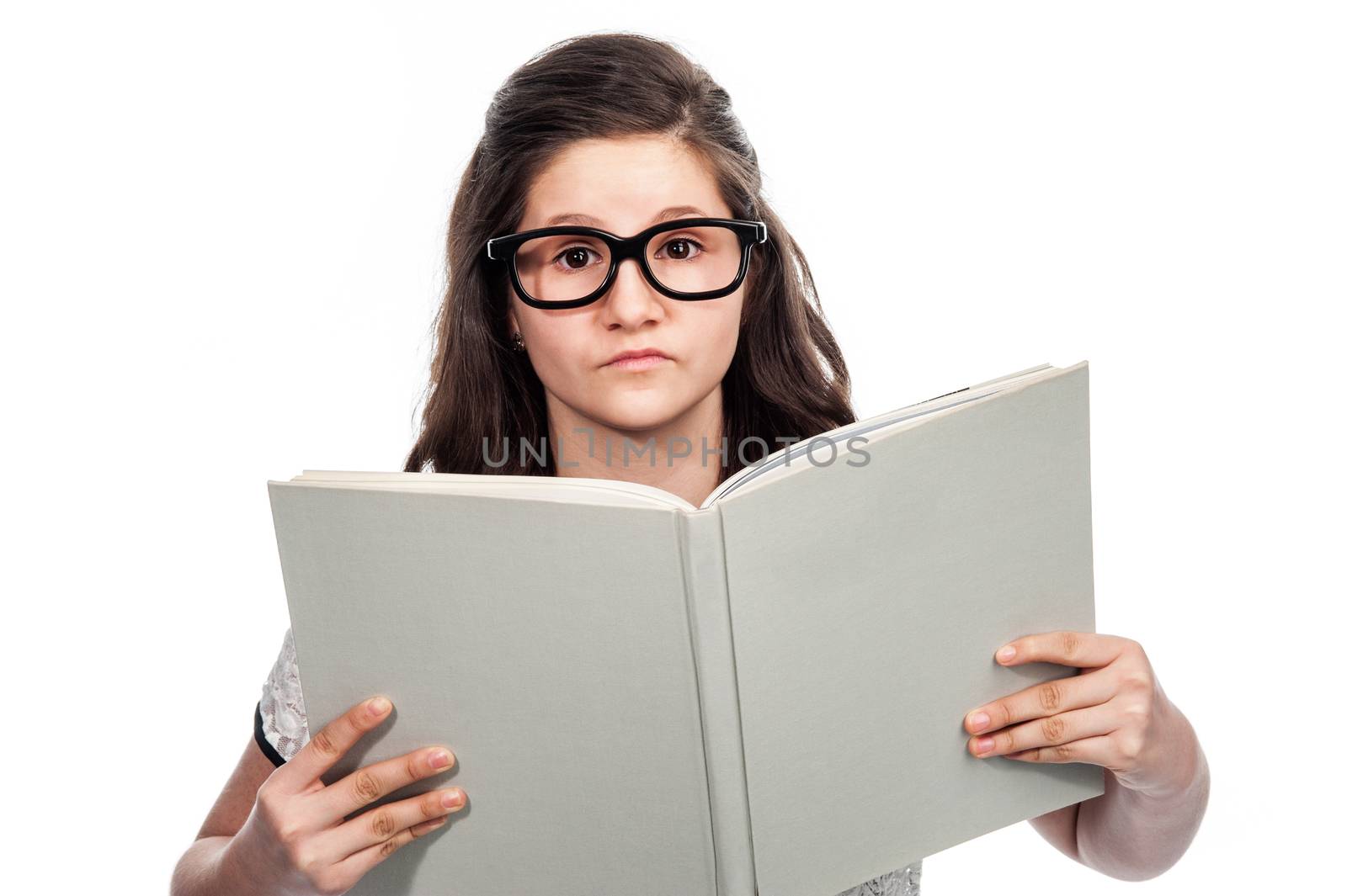 Brainy clever teenager with big glasses reading a big book on white background.