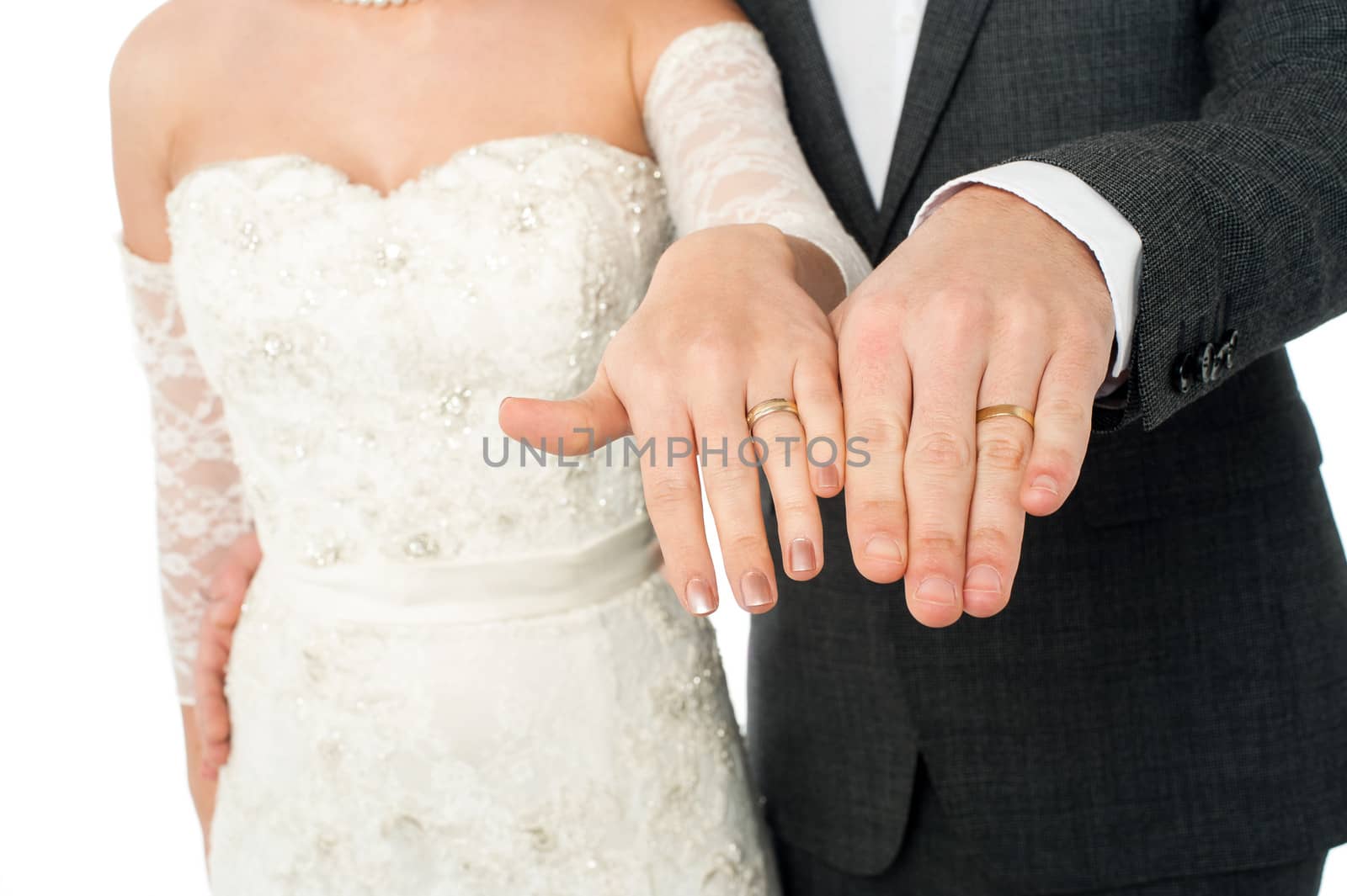 Bride and groom showing their wedding rings by stockyimages