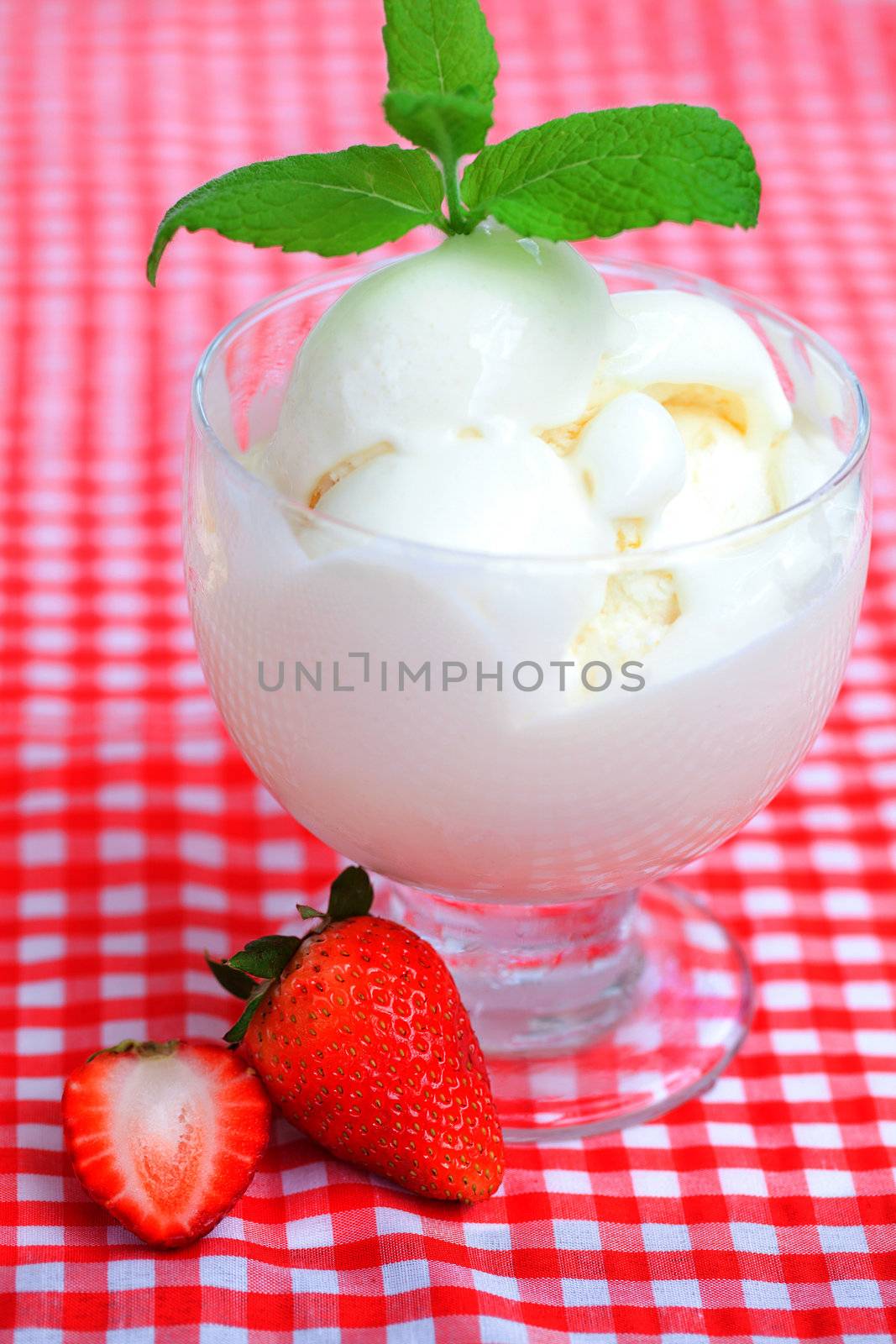 ice cream,strawberry with mint in a glass bowl on plaid fabric