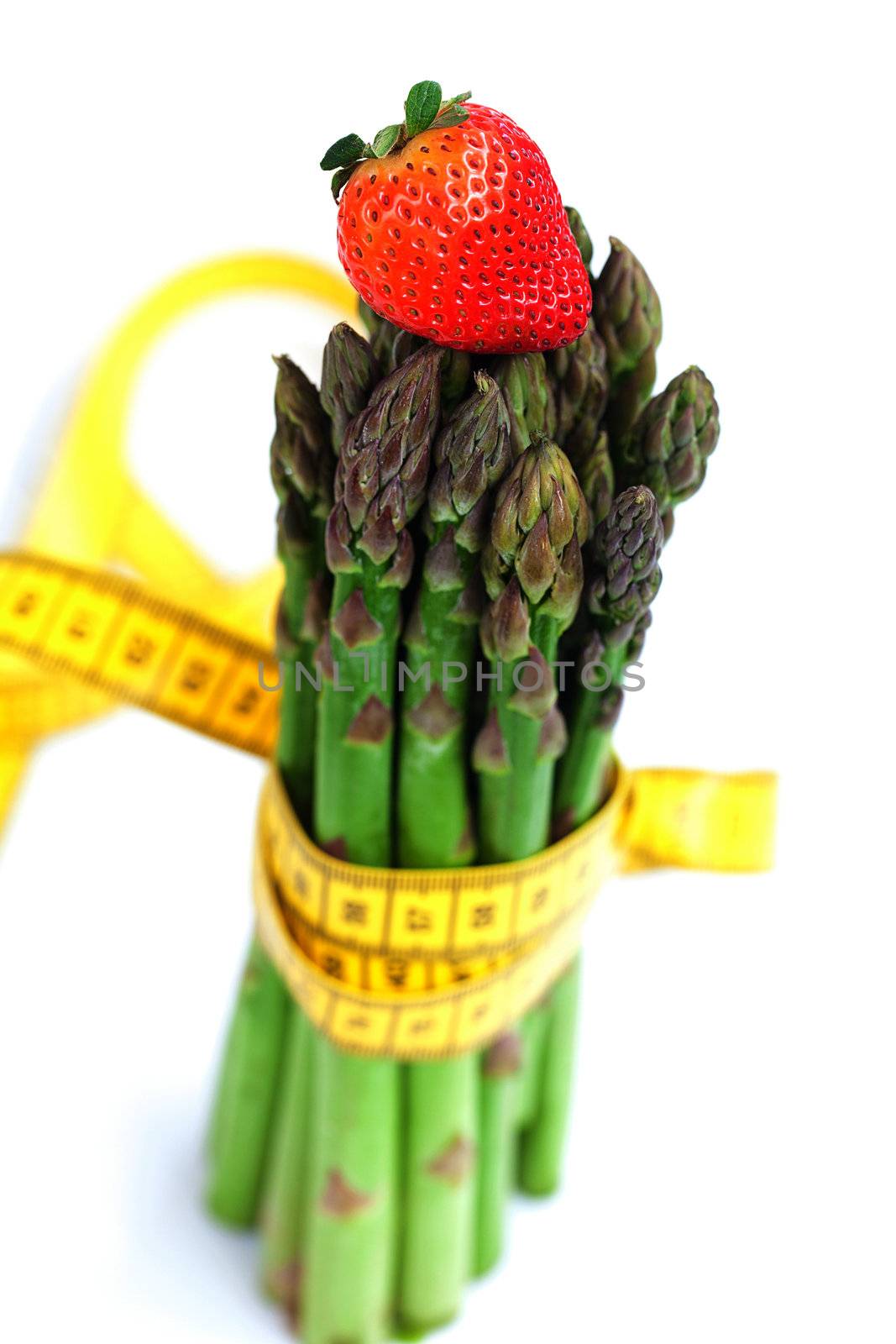 strawberry, asparagus tied with measuring tape isolated on white by jannyjus