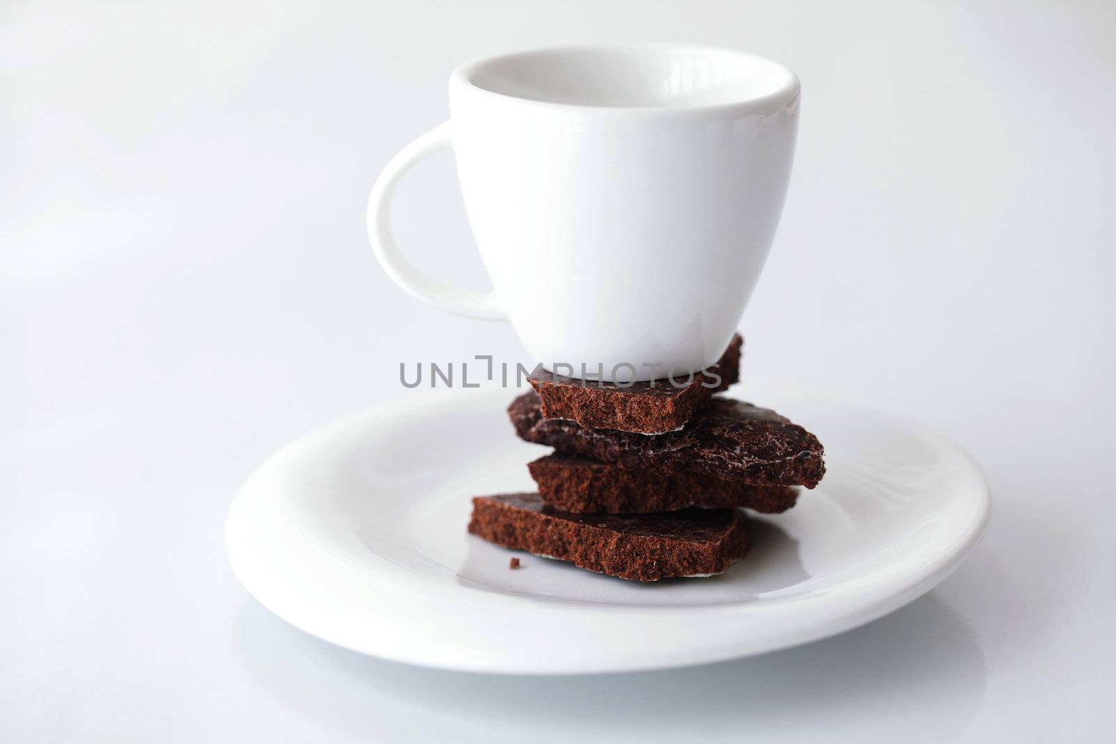 white cup with saucer and chocolate  by jannyjus