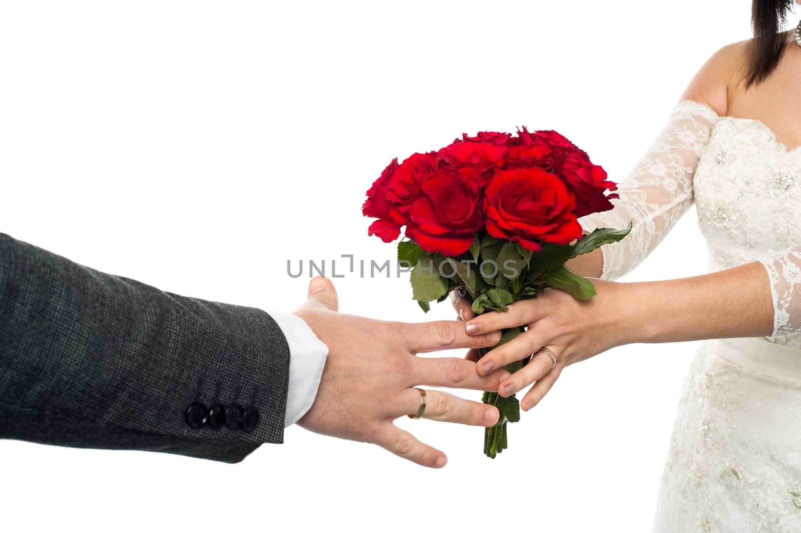 Closeup shot of a bride presenting a rose bouquet to the groom