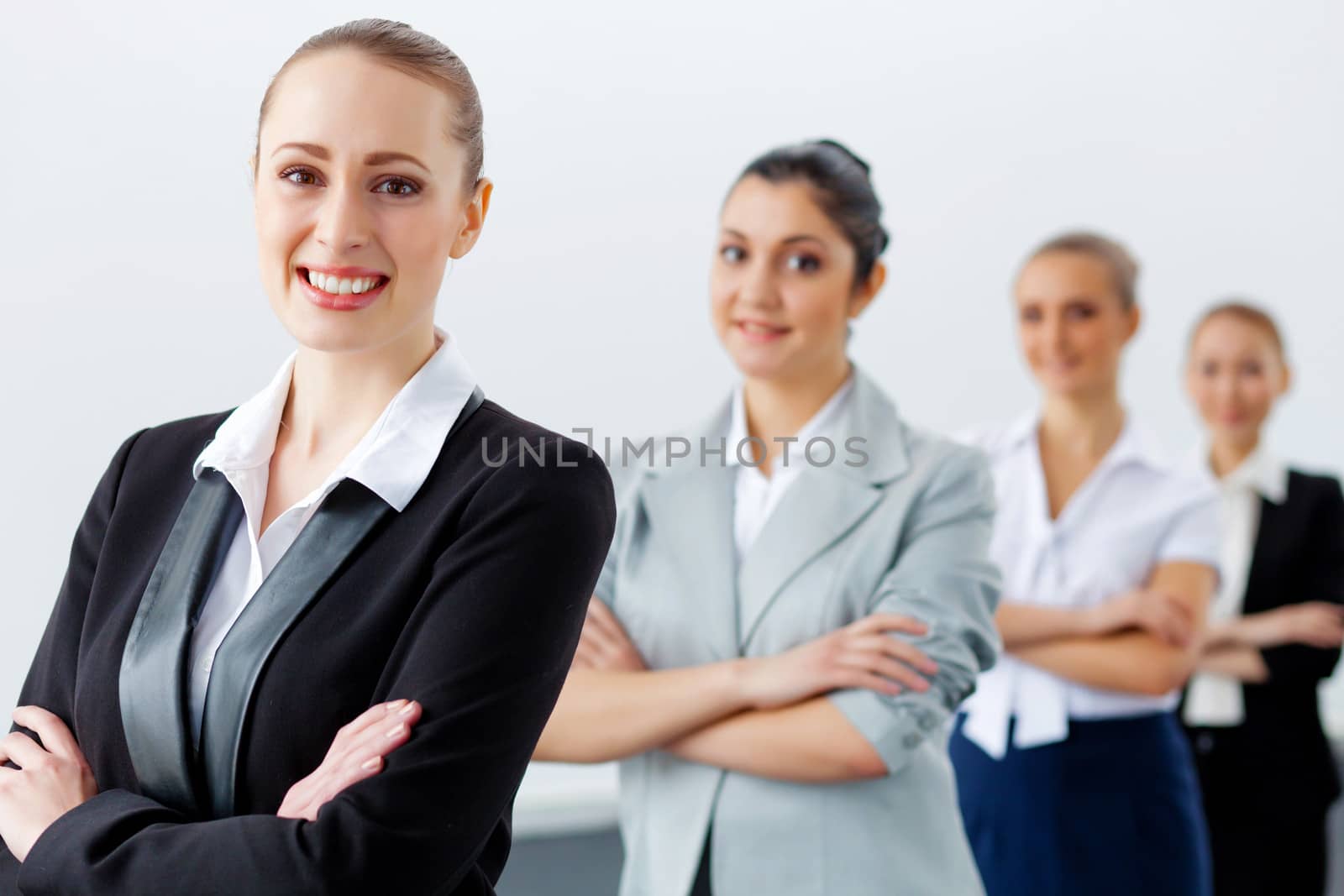 Image of four pretty young businesswomen standing in row