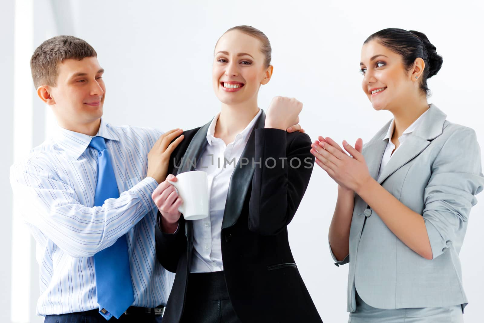 Image of three young businesspeople laughing joyfully