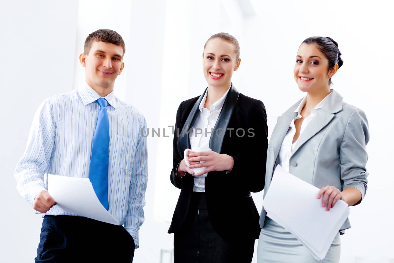 Image of three young businesspeople laughing joyfully