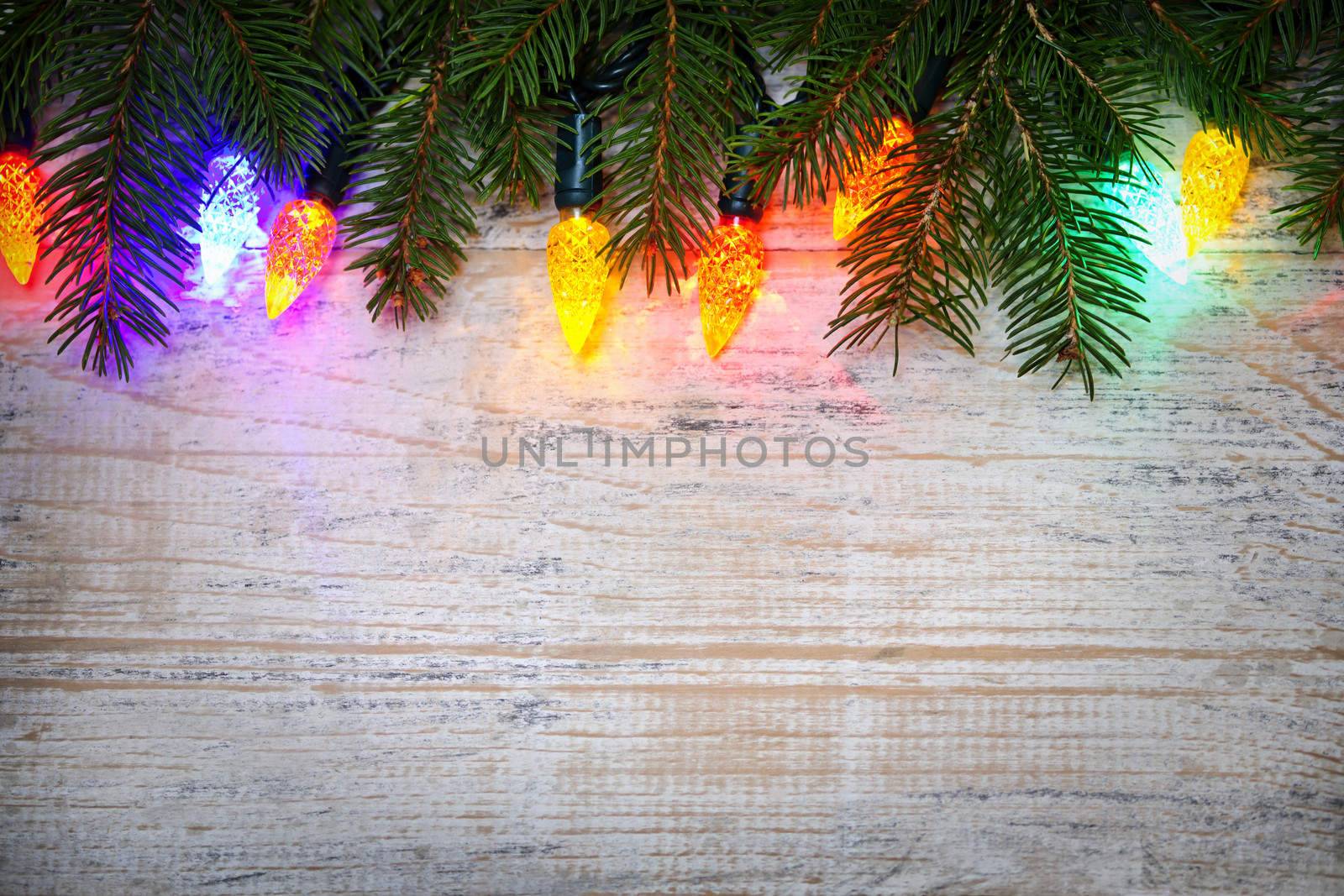 Christmas background with lights on branches by elenathewise