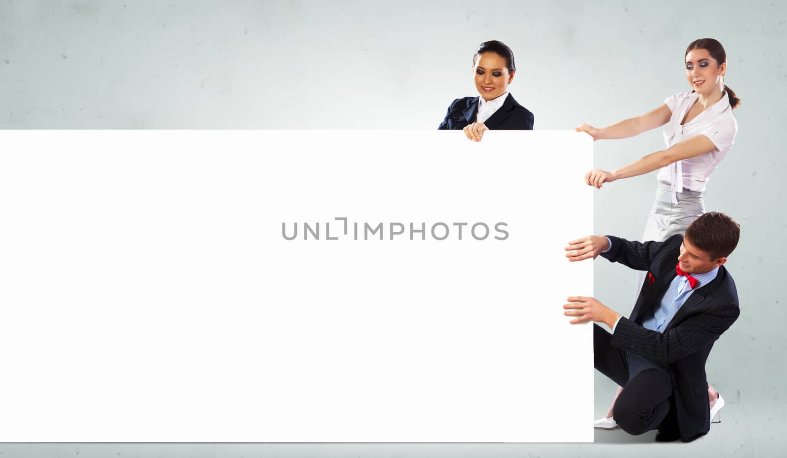 Image of three young people holding blank banner. Place for text