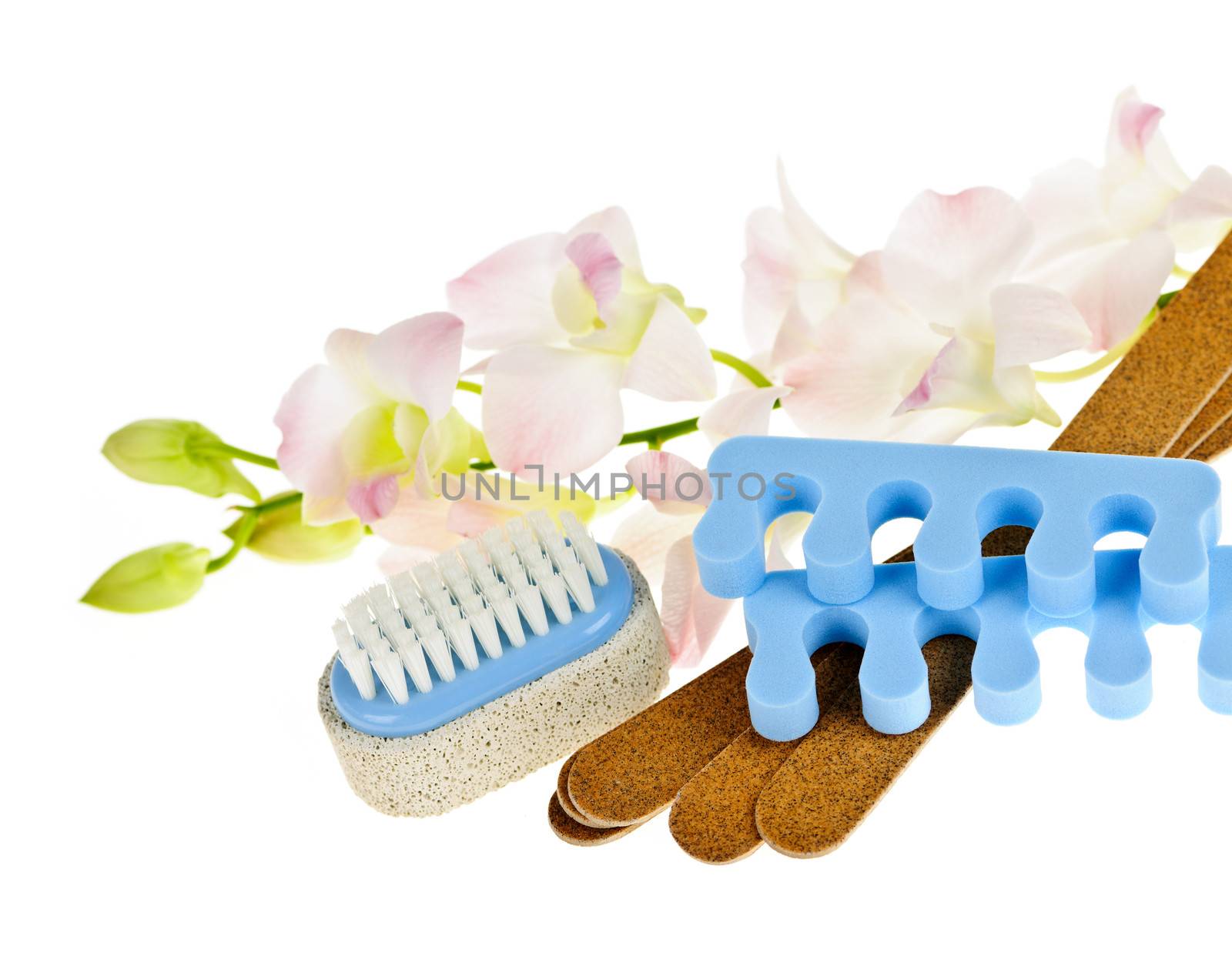 Pedicure accessories with orchid flowers on white background