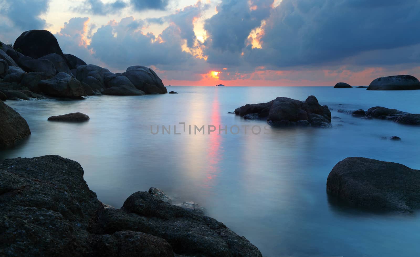 Dramatic sunset in rocky beach, Tanjung Pandan, Belitung, Indonesia. Long exposure shot