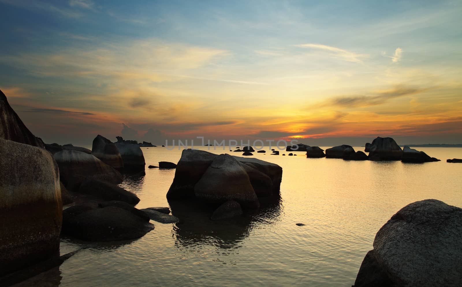 Dramatic sunrise in rocky beach