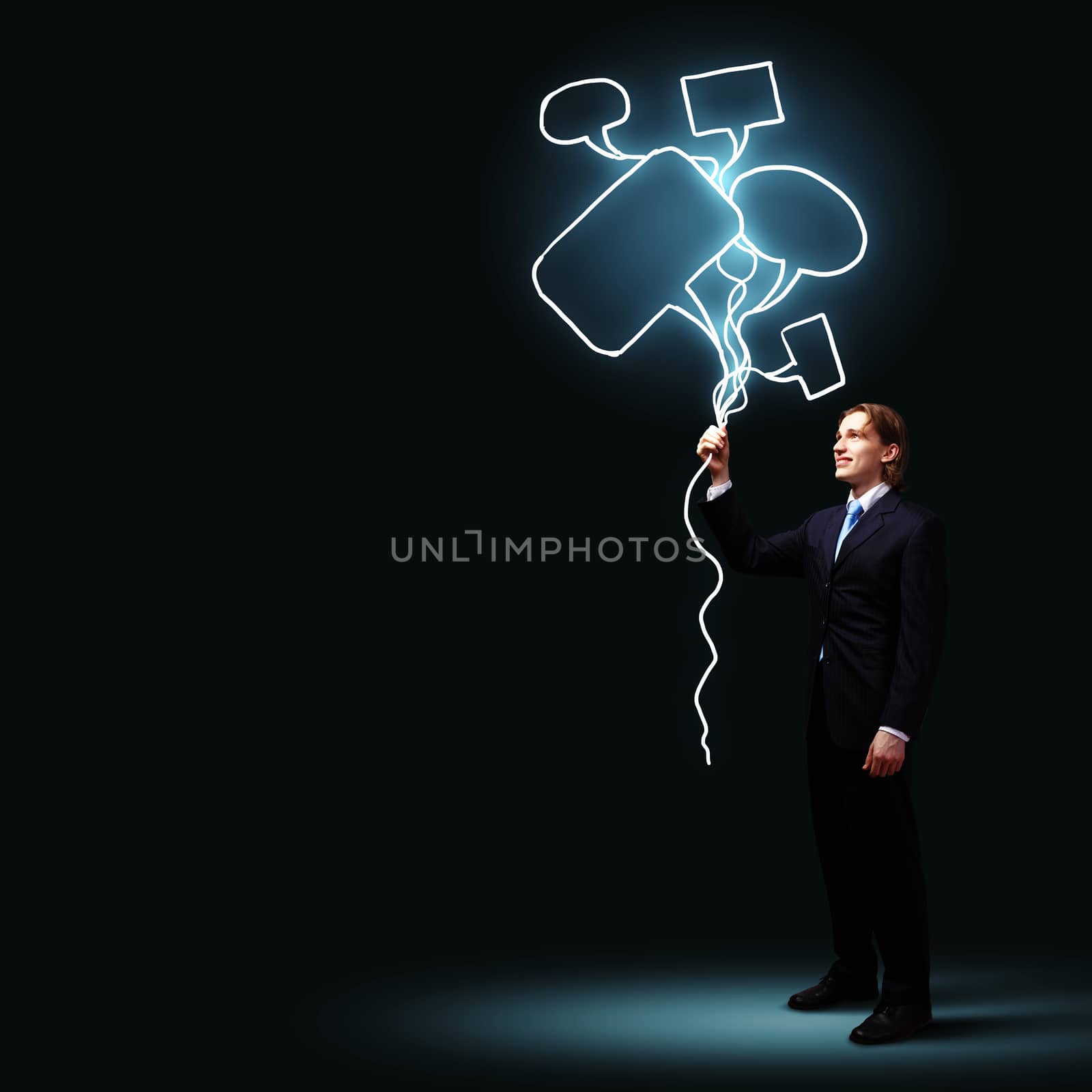 Image of businessman in black suit against dark background