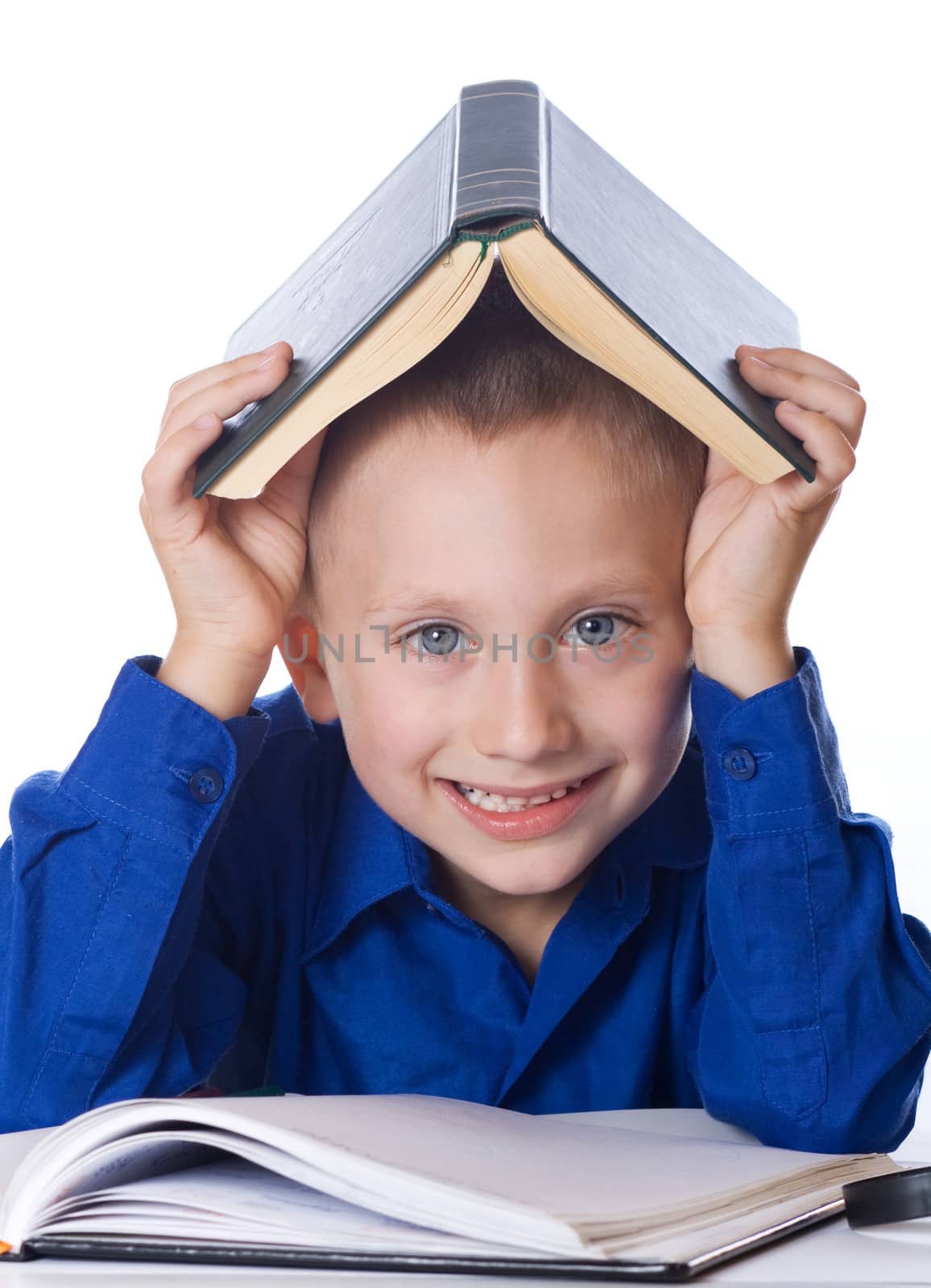 Schoolboy with open book on head on white background