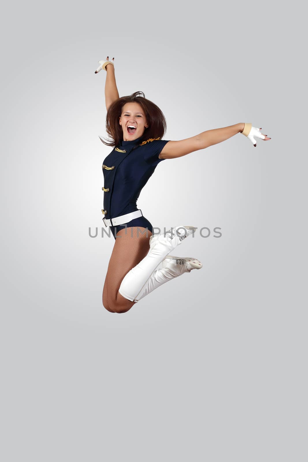 Young female dancer jumping against white background