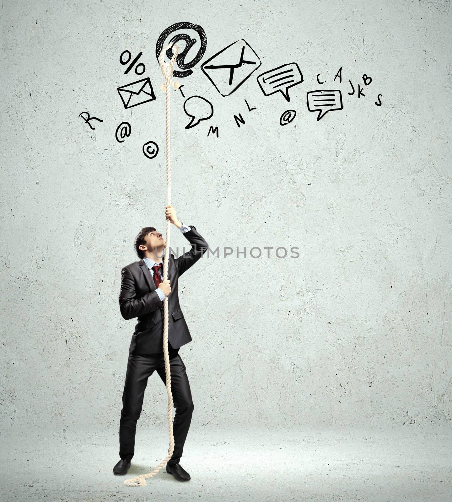 Image of young businessman pulling rope. Business collage
