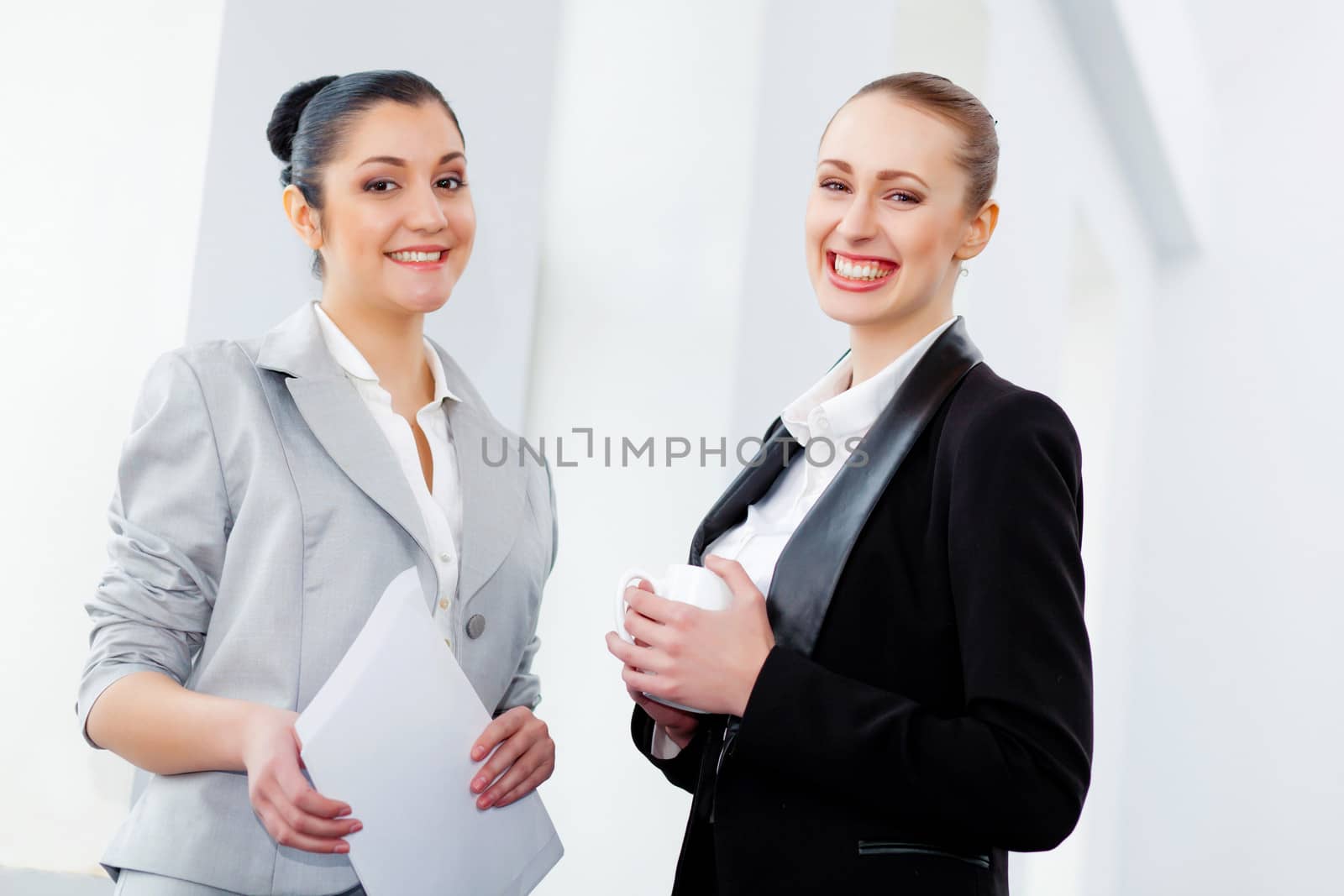 Two attractive business women smiling by sergey_nivens